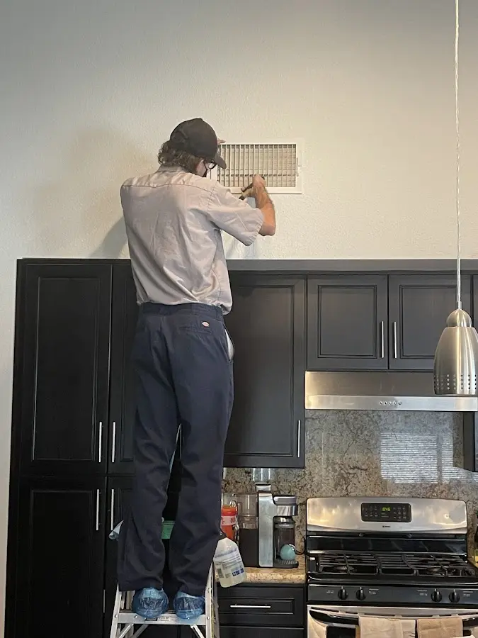 Technician inspecting an air vent during HVAC service in Winnemucca